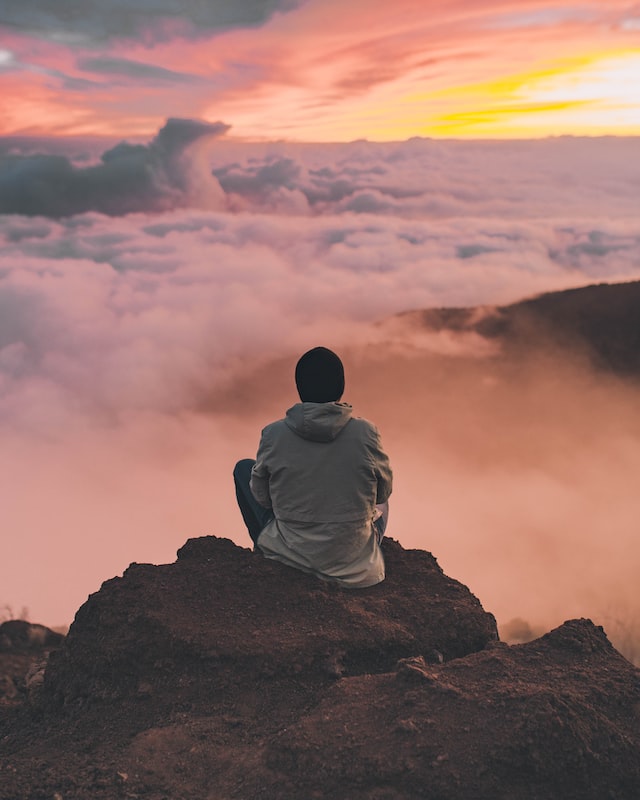 Man meditating on a top of the mountain