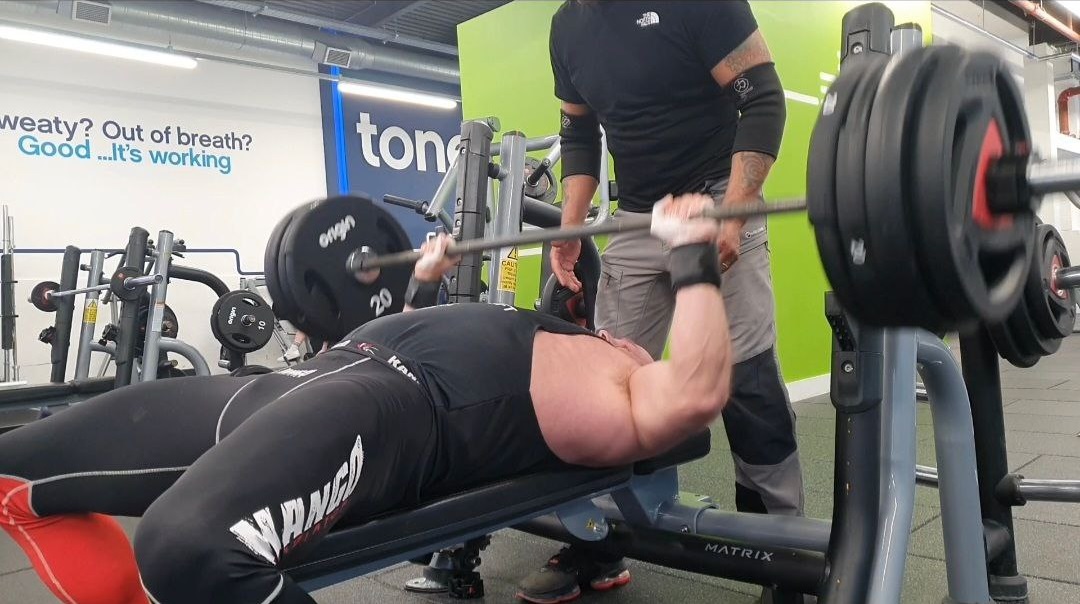 Piotr Strzala training bench press in the gym
