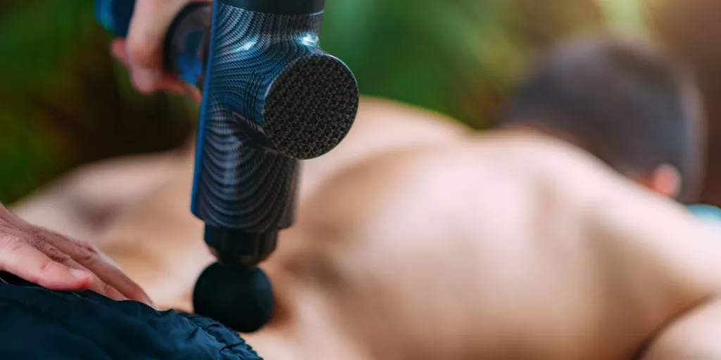 A sports massage gun being used in sports massage therapy