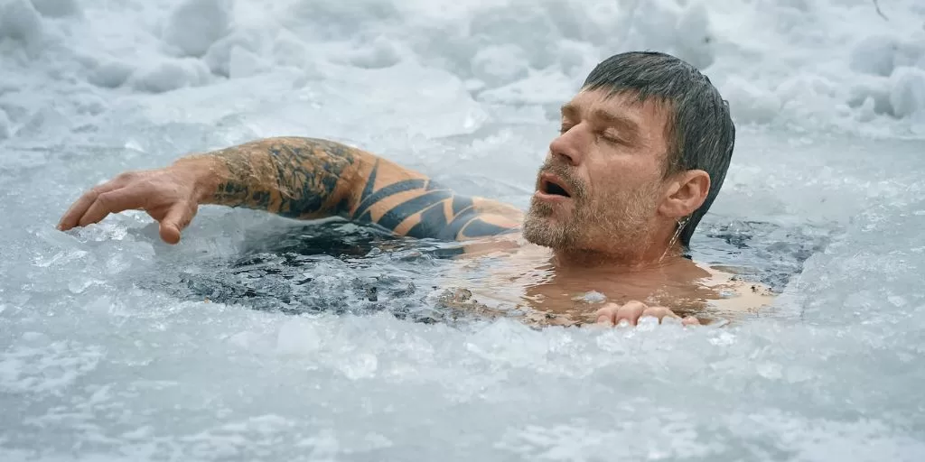 A man taking a bath in a frozen lake to train his mental strength