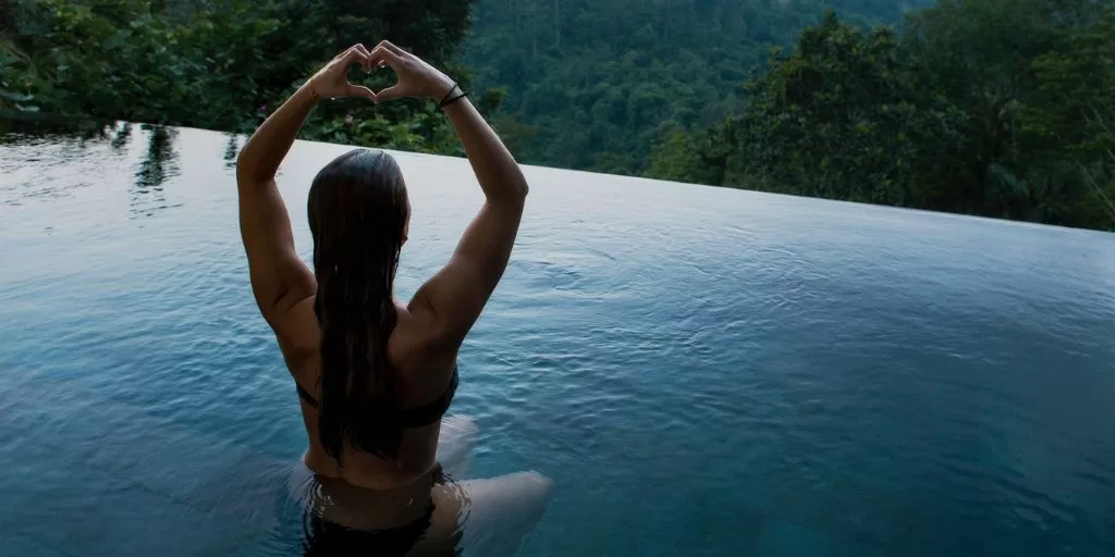 A woman making a heart gesture with her hands