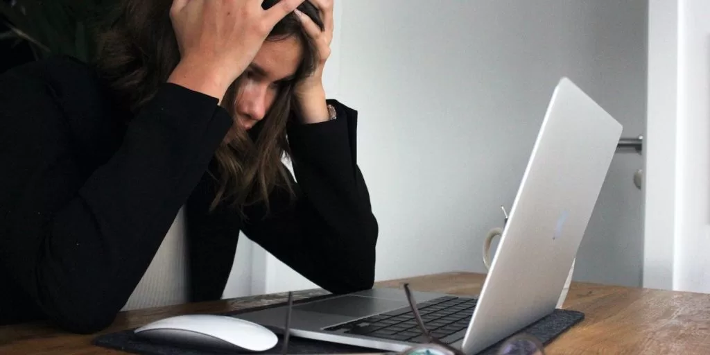 A stressed woman in front of a laptop