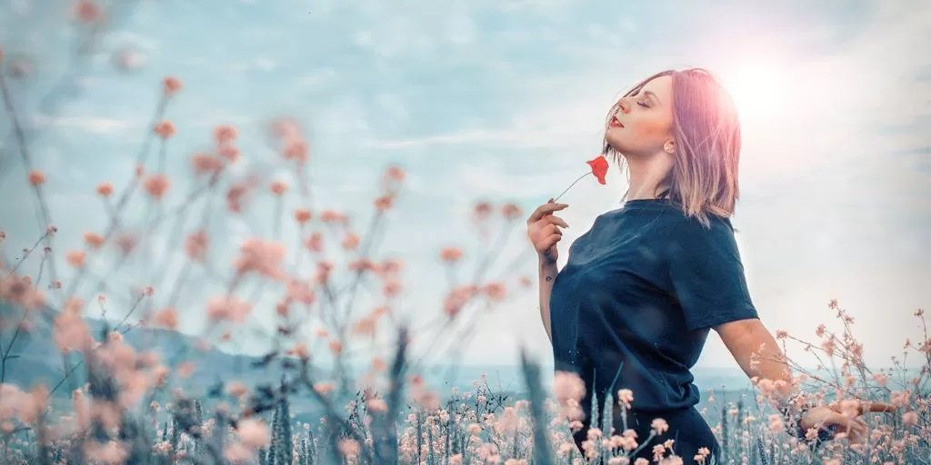 A happy woman smelling flowers ourdoors