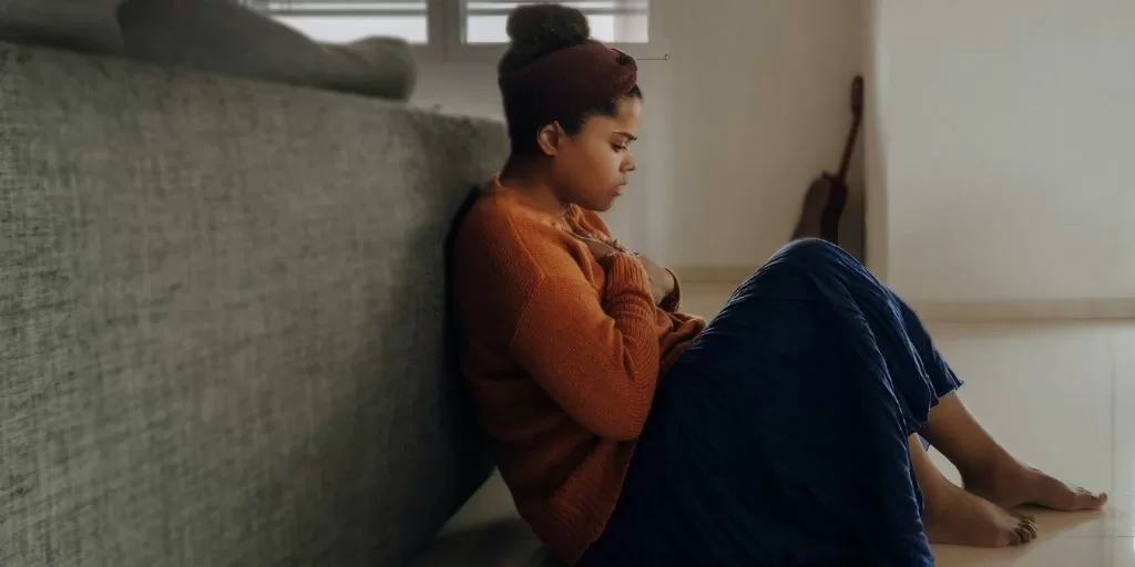 Anxious woman sitting on the floor