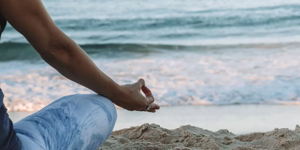 A woman meditating at the beach