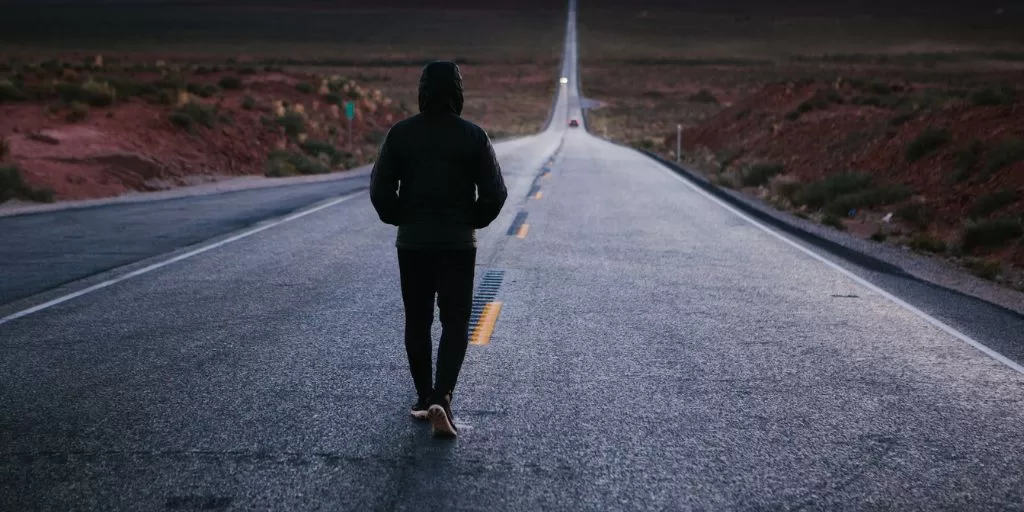 A motivated man walking down an endless road