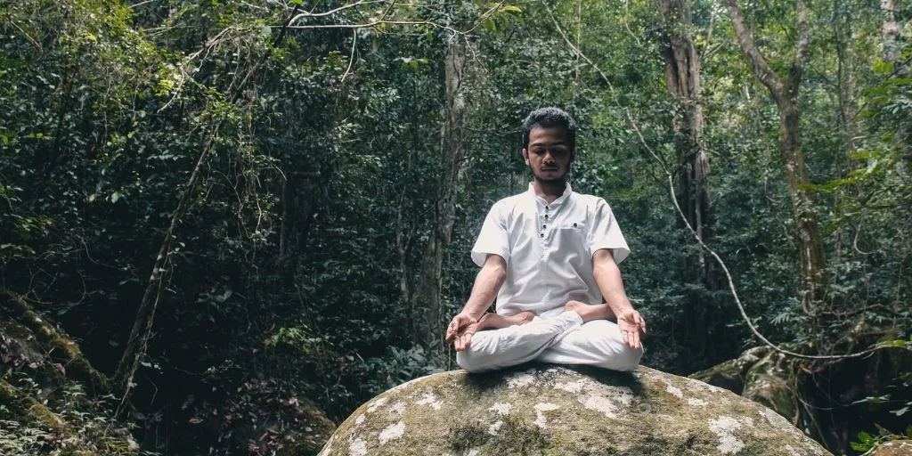 Man meditating on a rock