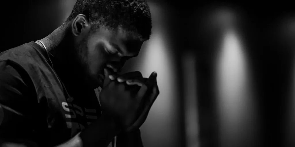 A black man immersed in a meditative prayer