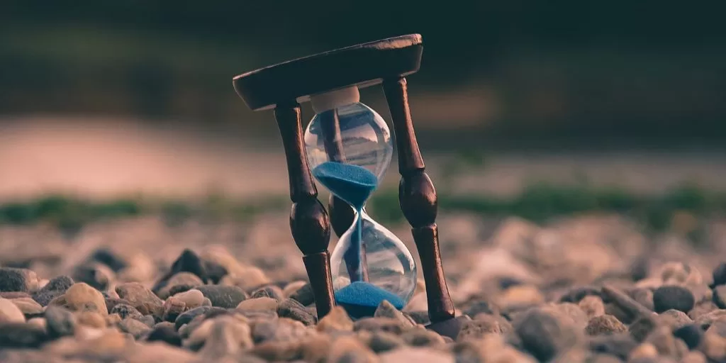 An hourglass standing on the sand