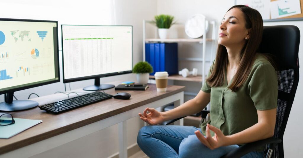 A Relaxed Woman Practicing Breathing Meditation At Work