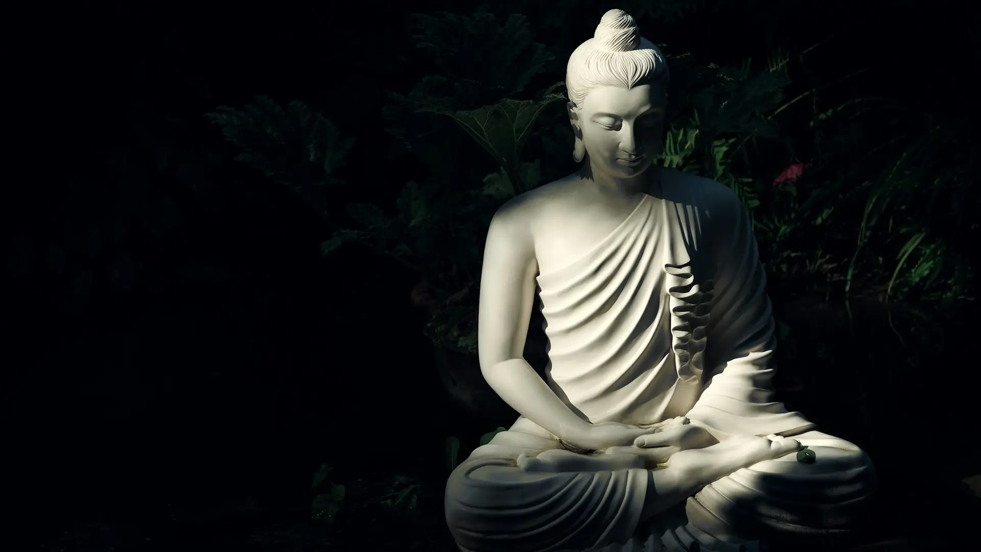 Buddha statue in a garden, symbolizing a meditation master