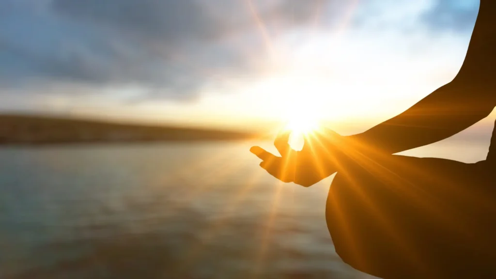 A person with ADHD meditating by a lake to calm themselves down