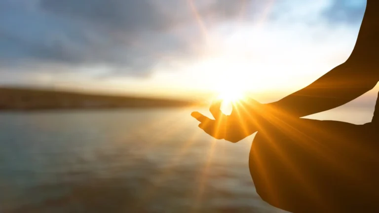A person with ADHD meditating by a lake to calm themselves down