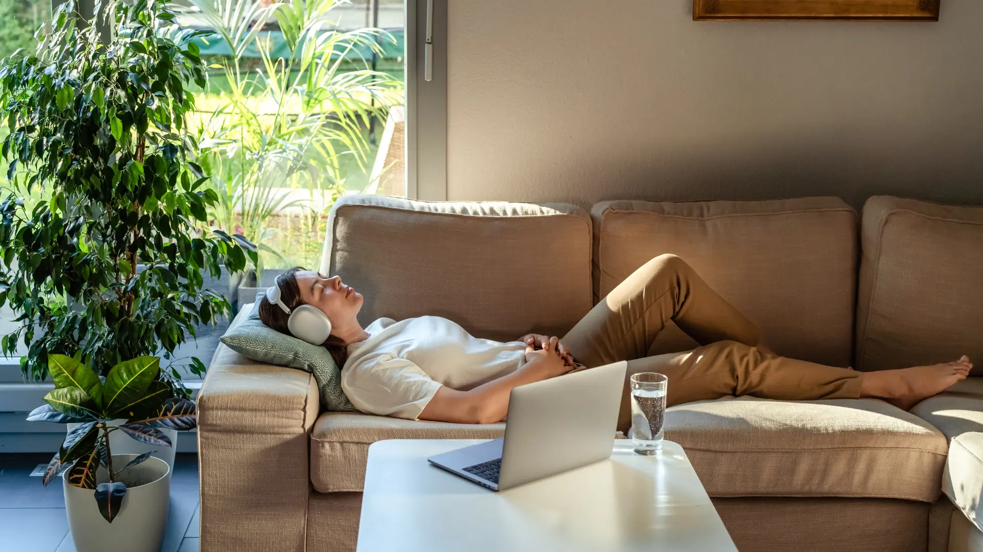 Autistic woman meditating on a couch with headphones on to calm herself down