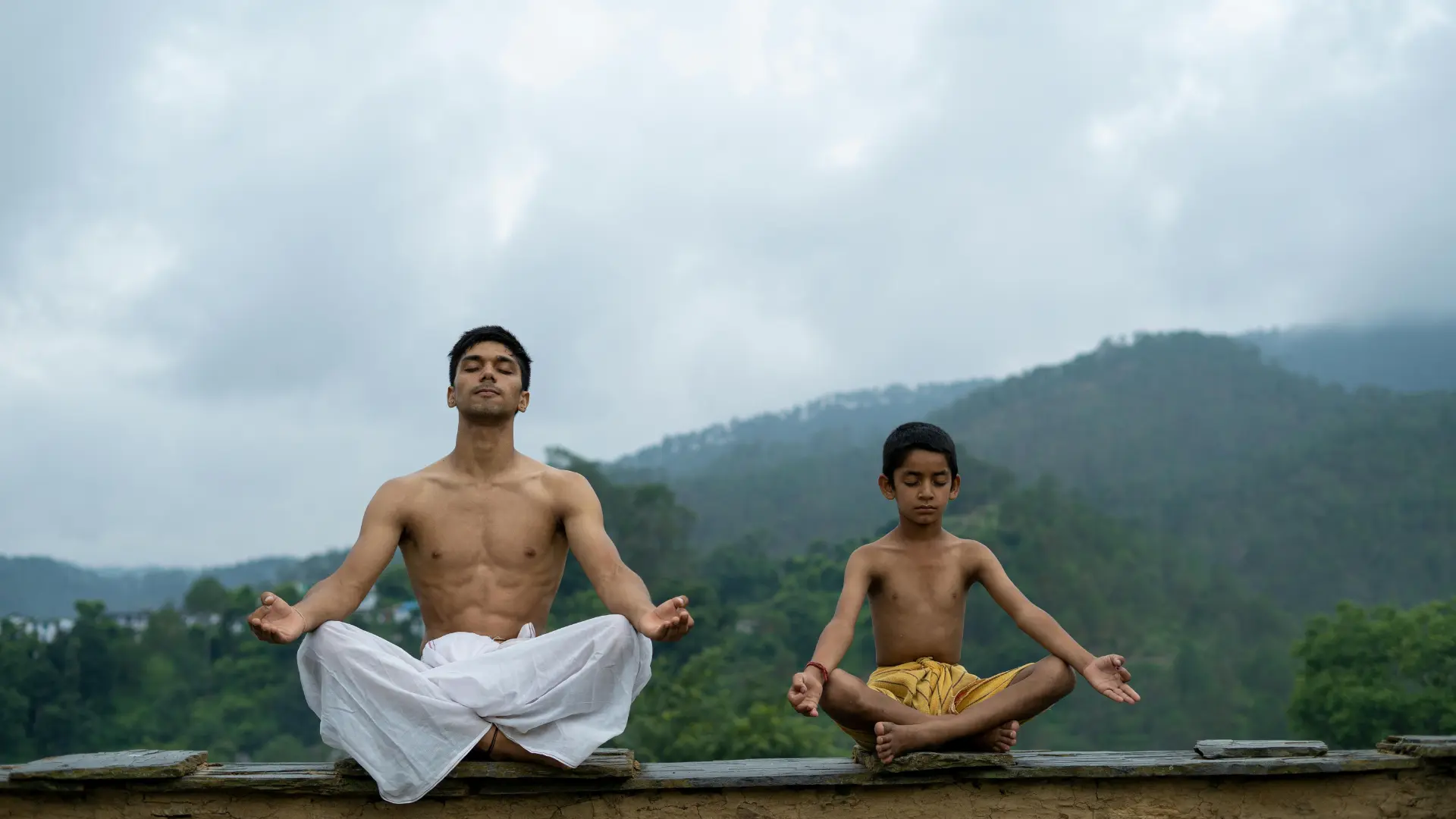 2 Indian people practicing yogic meditation (Dhyana) in the mountains