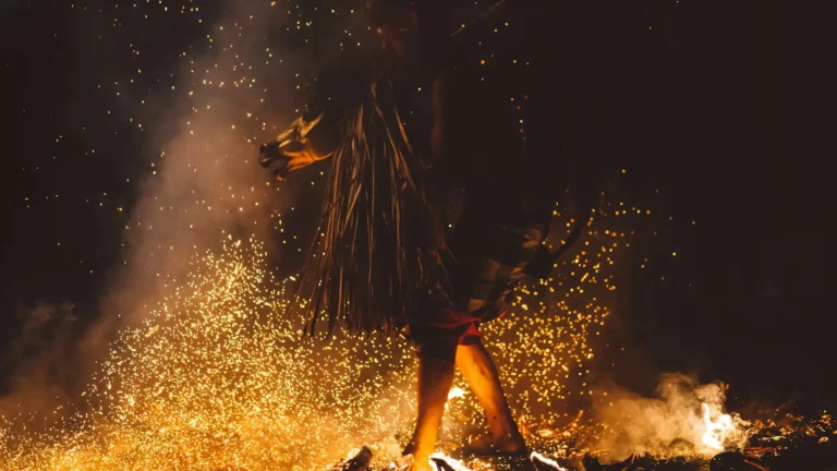 A shamanic healer walking on fire during a ritual
